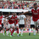 A photo of the Arsenal Team celebrating after a goal.